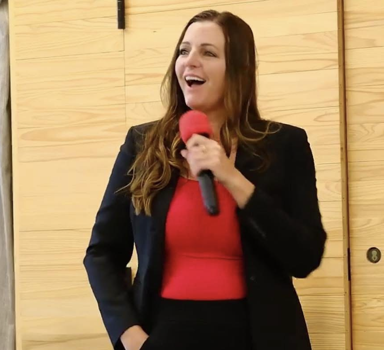 Jen Karpinko speaking into a microphone